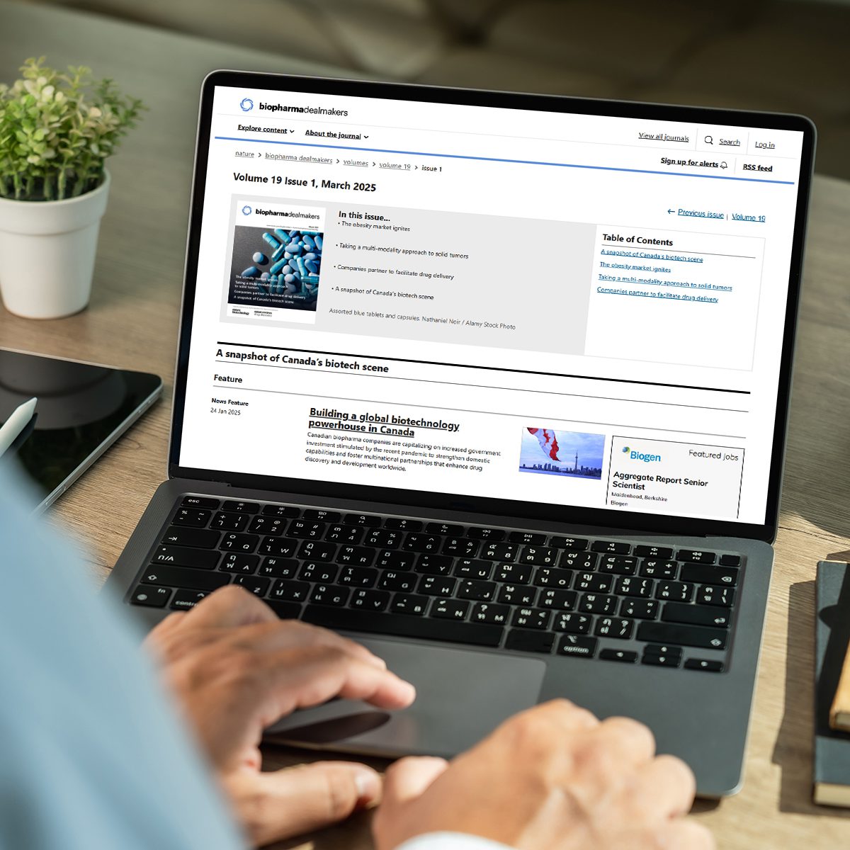 Businessman using a desktop computer with Biopharma Dealmakers website on screen