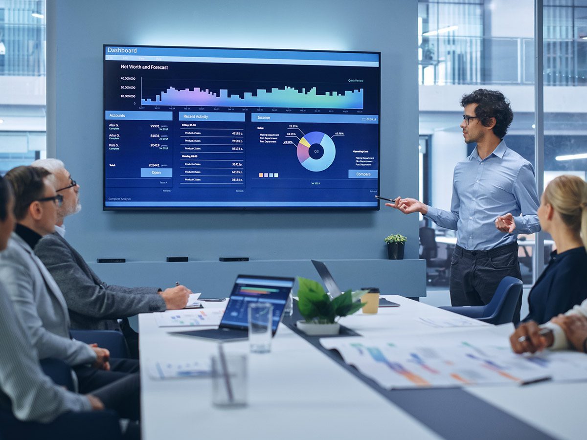 A business meeting centered around a large screen
